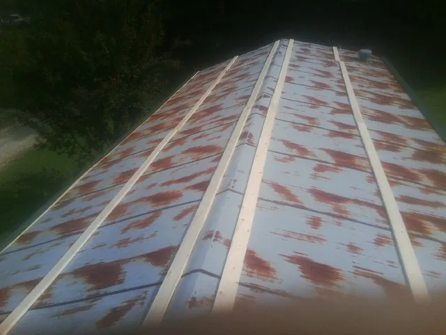 Rusted metal roof panels with new wood purlins before replacement — Storm Damage Roof Repair in Tunica by Roofing Brothers
