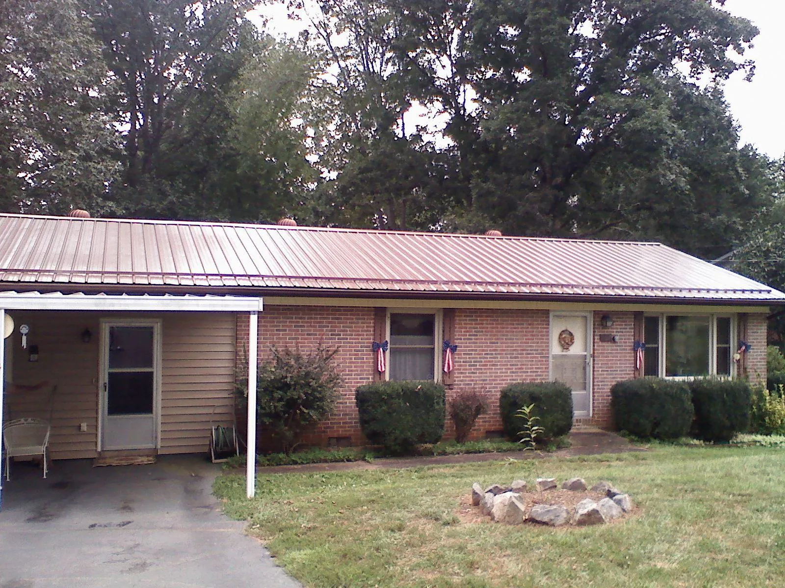 Bronze metal roof and carport on a brick ranch home — Roof Repair work by our crew in Tunica